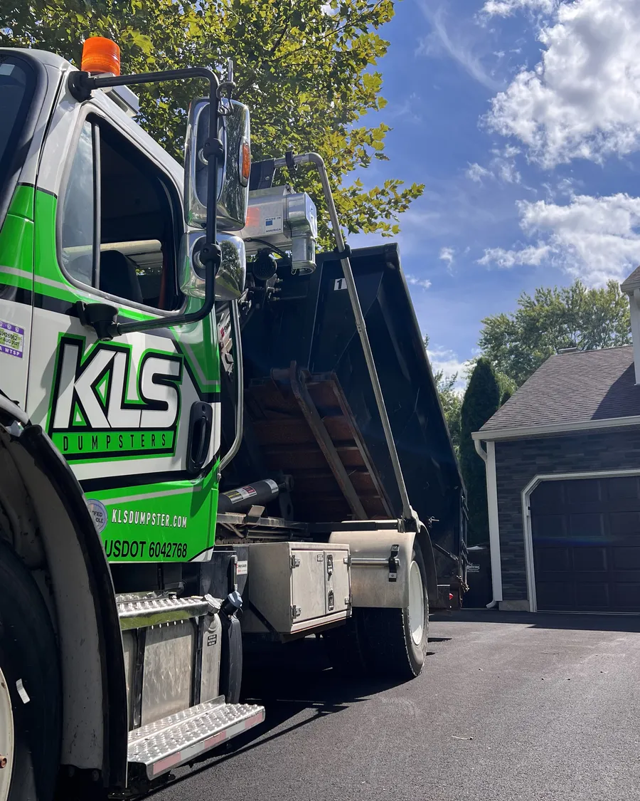 KLS Dumpster roll-off truck delivering a container to a home driveway in Telford, PA